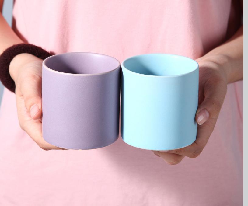 purple and baby blue cylinder pot being held by a person wearing baby pink shirt - Plant Studio